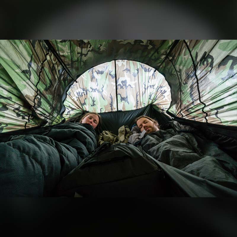 Two people lying in a Clark VX-Ultra under the open mosquito net